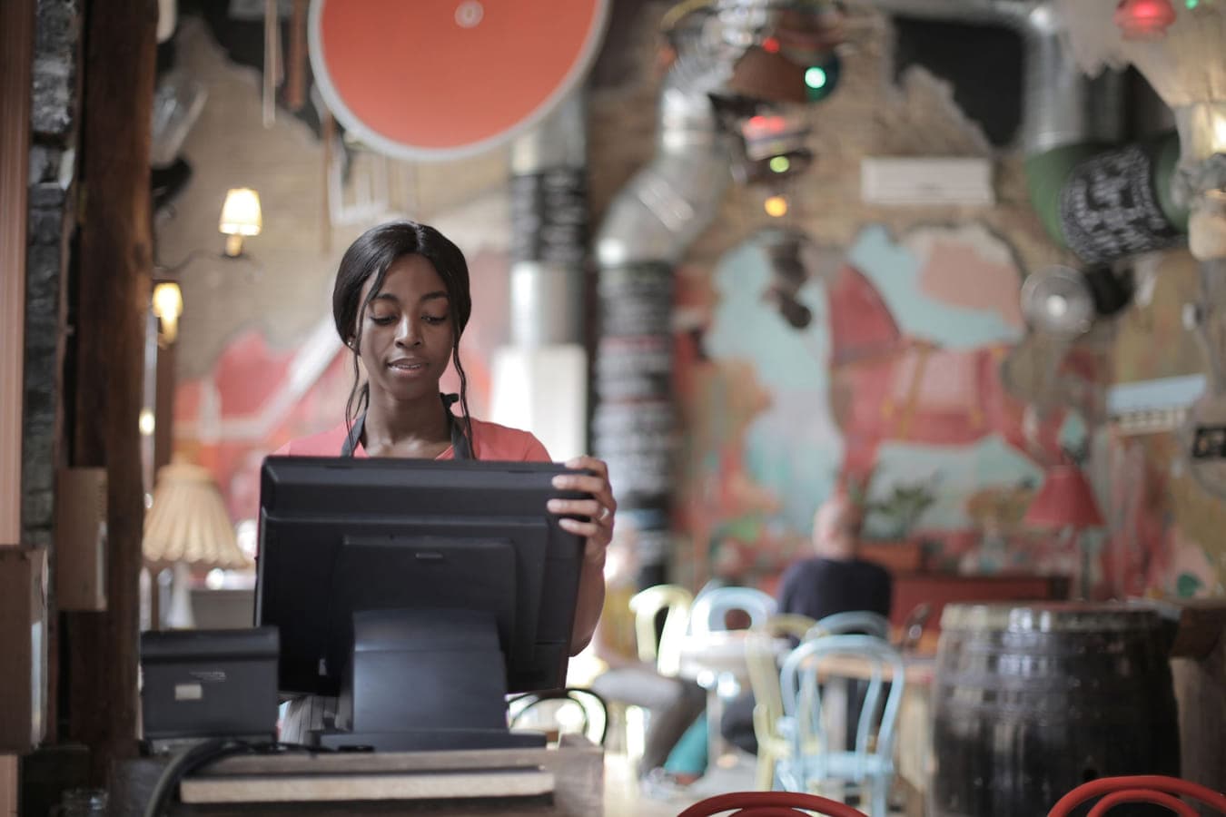 A countertop till in use behind a restaurant counter